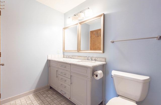 9309 Loch Lomond Ln, Brooklyn Park, MN 55443 - bathroom featuring double vanity, toilet, baseboards, and tile patterned floors