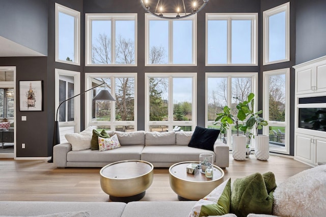 330 Lythrum Ln, Medina, MN 55340 - living area with a high ceiling, light wood-style flooring, and a chandelier