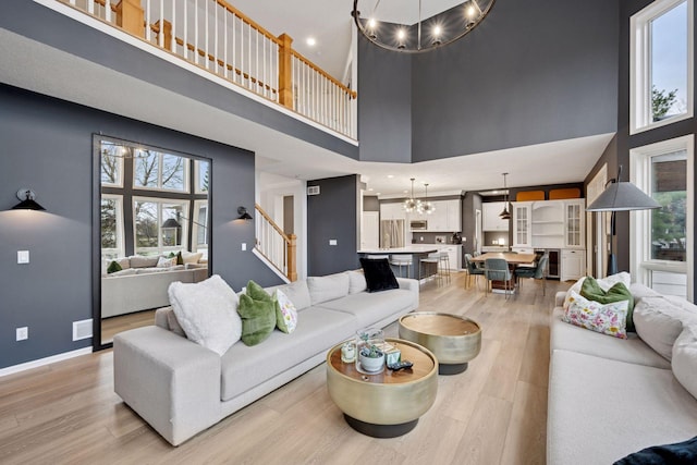 330 Lythrum Ln, Medina, MN 55340 - living area with a chandelier, a towering ceiling, light wood-style floors, healthy amount of natural light, and recessed lighting