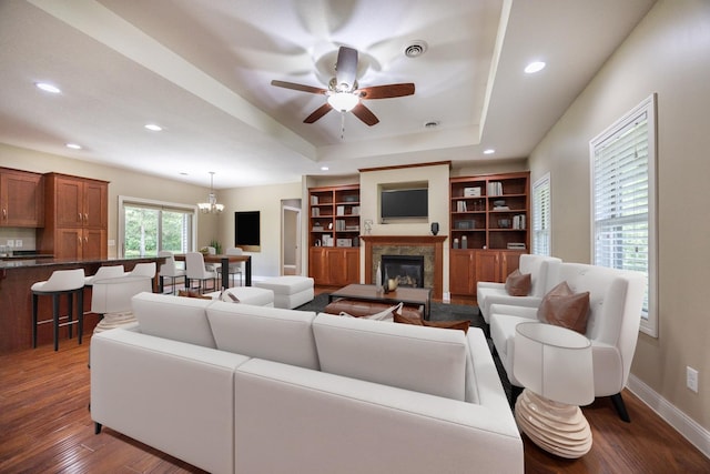 67457 152nd Ave, Greenfield Twp, MN 55981 - living area with dark wood-style flooring, a premium fireplace, ceiling fan, recessed lighting, and a raised ceiling