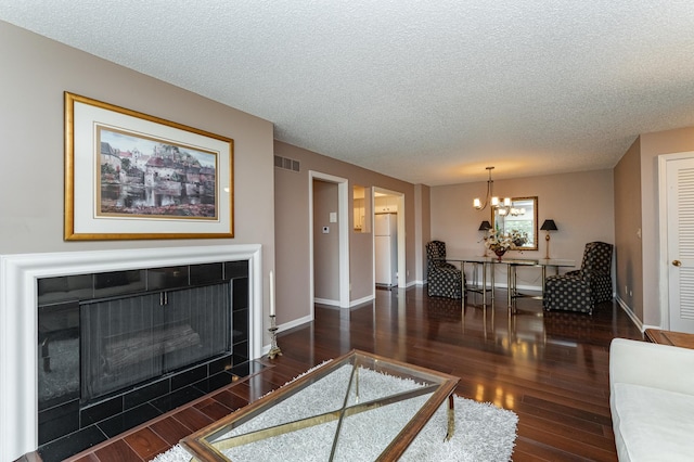 2051 Carriage Dr SW Unit 2051A, Rochester, MN 55902 - living room with wood finished floors, a textured ceiling, a chandelier, baseboards, and a tile fireplace