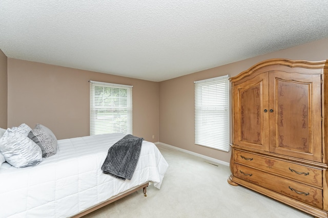 2051 Carriage Dr SW Unit 2051A, Rochester, MN 55902 - bedroom featuring light carpet, a textured ceiling, and baseboards