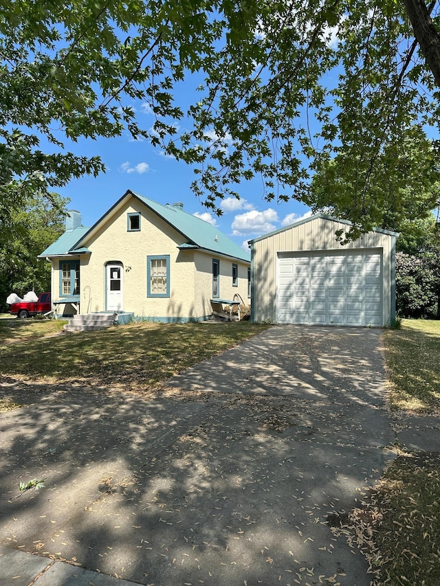 502 1st Ave SE, Baudette, MN 56623 - view of front of home with a garage, driveway, an outbuilding, and a chimney