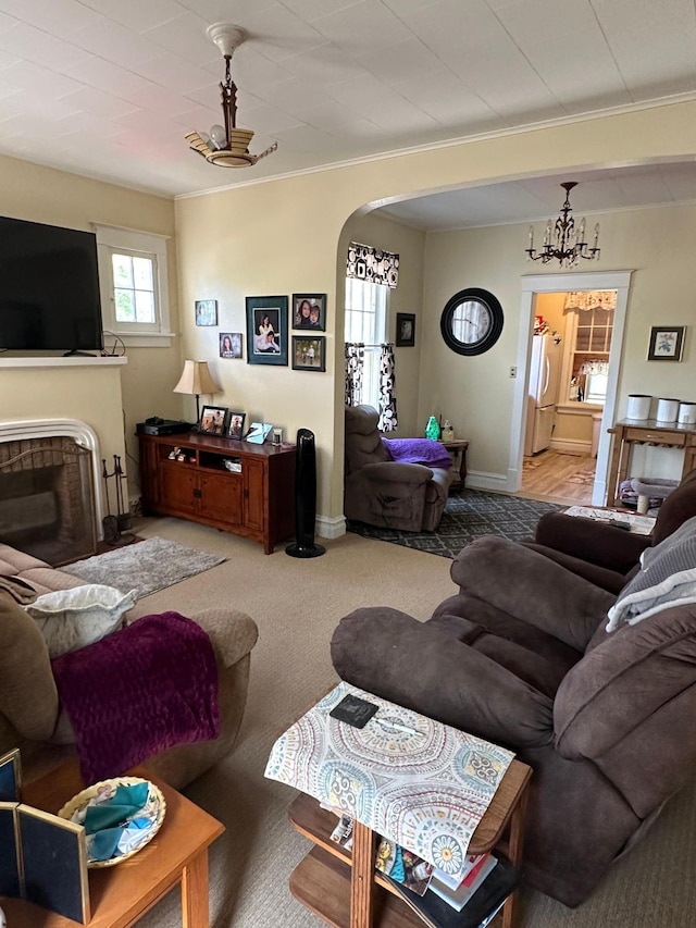 502 1st Ave SE, Baudette, MN 56623 - carpeted living area featuring arched walkways, crown molding, a fireplace, and baseboards