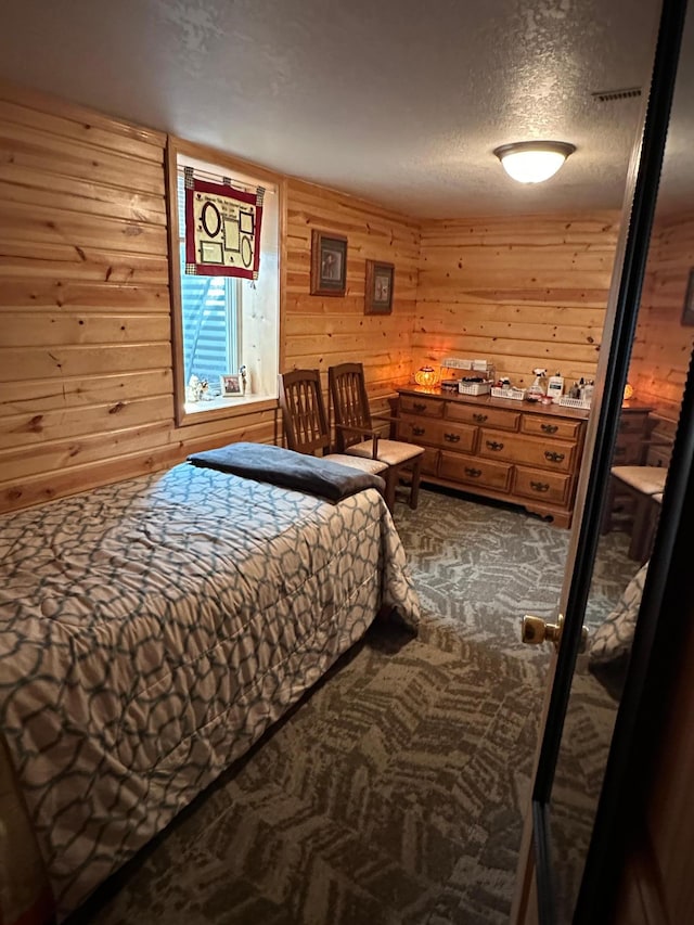 502 1st Ave SE, Baudette, MN 56623 - bedroom featuring dark colored carpet, wooden walls, and a textured ceiling