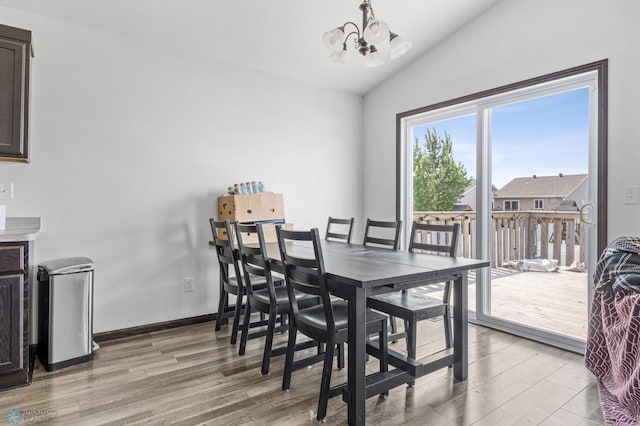 2128 Admiral Dr W, West Fargo, ND 58078 - dining space featuring light wood-type flooring, a chandelier, lofted ceiling, and baseboards