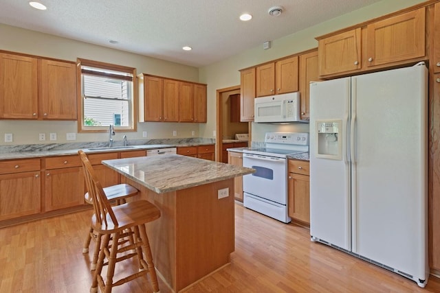 1223 Cypress Dr W, Annandale, MN 55302 - kitchen featuring white appliances, a sink, a center island, light wood-type flooring, and a kitchen breakfast bar