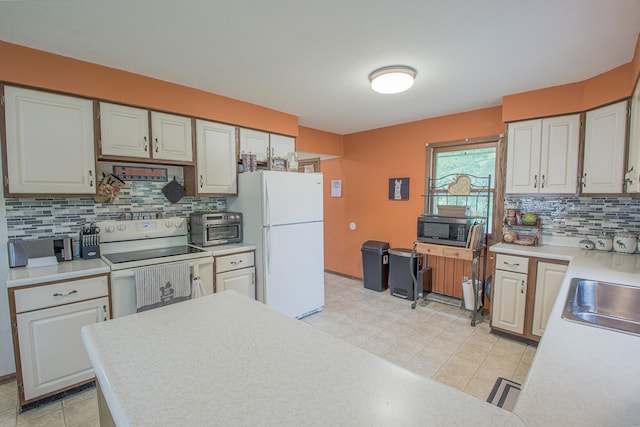 1221 11th St SE, Saint Cloud, MN 56304 - kitchen featuring white appliances, light countertops, decorative backsplash, and a sink