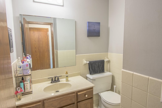 1221 11th St SE, Saint Cloud, MN 56304 - half bath with tile walls, toilet, vanity, and a wainscoted wall