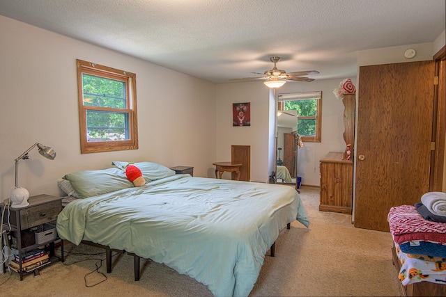 1221 11th St SE, Saint Cloud, MN 56304 - bedroom with light carpet, multiple windows, ceiling fan, and a textured ceiling