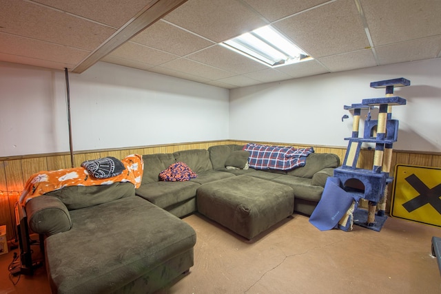 1221 11th St SE, Saint Cloud, MN 56304 - living room with a drop ceiling, a wainscoted wall, wood walls, and concrete floors
