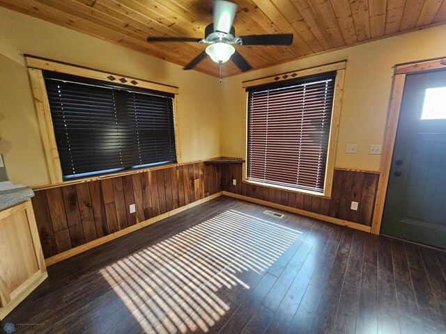 609 1st St N, Wahpeton, ND 58075 - empty room featuring dark wood-style flooring, a wainscoted wall, wooden walls, wooden ceiling, and a ceiling fan