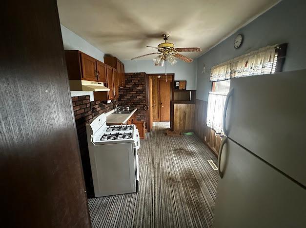 5336 44th Ave S, Minneapolis, MN 55417 - kitchen featuring white appliances, under cabinet range hood, ceiling fan, carpet, and wainscoting