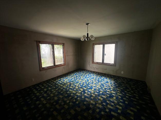5336 44th Ave S, Minneapolis, MN 55417 - carpeted empty room featuring a chandelier and healthy amount of natural light