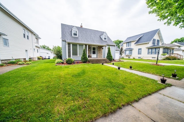 109 2nd St SW, Blooming Prairie, MN 55917 - new england style home featuring a porch, a front yard, a chimney, a residential view, and a shingled roof