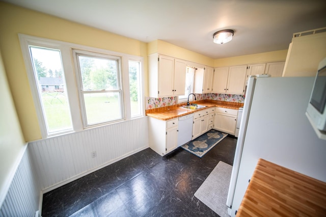 109 2nd St SW, Blooming Prairie, MN 55917 - kitchen featuring a sink, white appliances, wainscoting, white cabinetry, and light countertops