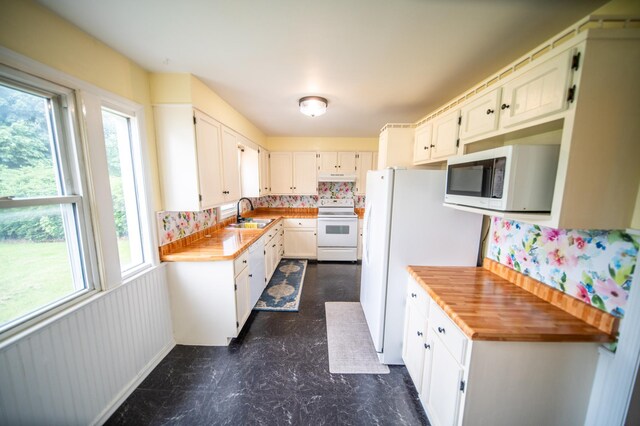 109 2nd St SW, Blooming Prairie, MN 55917 - kitchen featuring white appliances, a sink, dark floors, tasteful backsplash, and white cabinetry