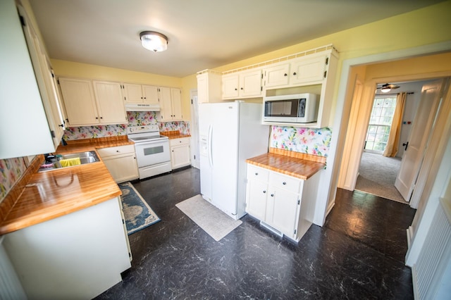 109 2nd St SW, Blooming Prairie, MN 55917 - kitchen with white appliances, butcher block counters, tasteful backsplash, a sink, and under cabinet range hood