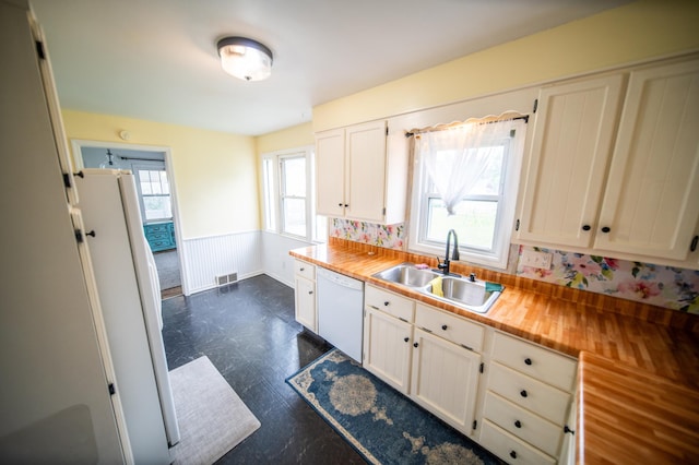 109 2nd St SW, Blooming Prairie, MN 55917 - kitchen with white appliances, a sink, dark floors, white cabinetry, and butcher block countertops