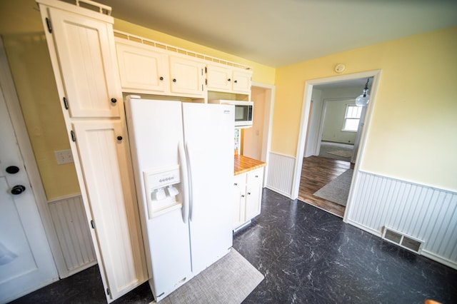 109 2nd St SW, Blooming Prairie, MN 55917 - kitchen with white fridge with ice dispenser, wainscoting, stainless steel microwave, light countertops, and white cabinets