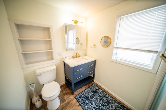 109 2nd St SW, Blooming Prairie, MN 55917 - bathroom featuring vanity, toilet, wood finished floors, and baseboards
