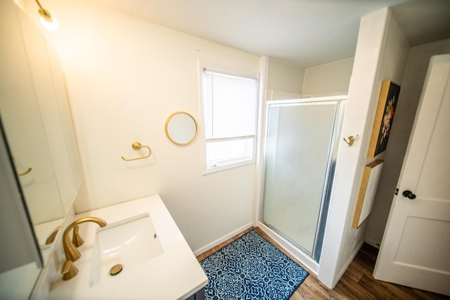 109 2nd St SW, Blooming Prairie, MN 55917 - bathroom featuring a shower stall, vanity, wood finished floors, and baseboards