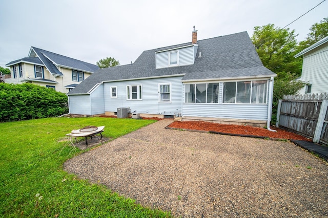109 2nd St SW, Blooming Prairie, MN 55917 - rear view of house featuring central air condition unit, a chimney, an outdoor fire pit, a sunroom, and a shingled roof