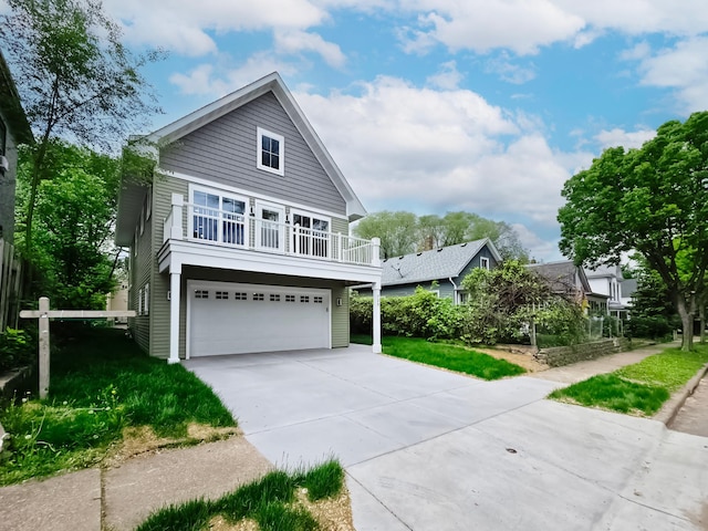 729 Burr St N, Saint Paul, MN 55130 - view of front facade featuring a garage, concrete driveway, and a balcony