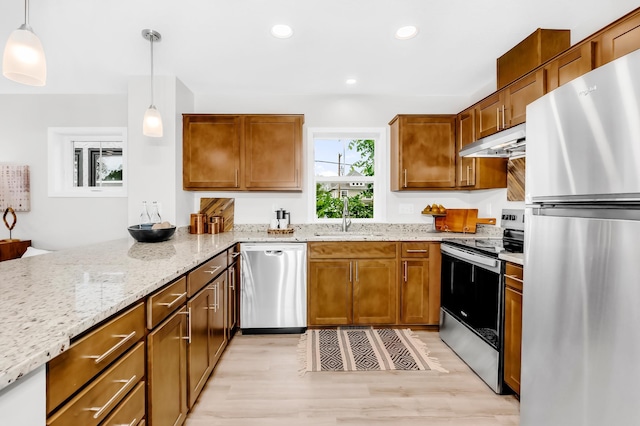 729 Burr St N, Saint Paul, MN 55130 - kitchen with appliances with stainless steel finishes, under cabinet range hood, a sink, light stone countertops, and a peninsula