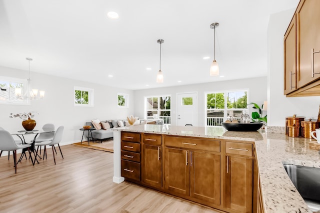 729 Burr St N, Saint Paul, MN 55130 - kitchen featuring plenty of natural light, a peninsula, recessed lighting, light wood-style flooring, and light stone countertops