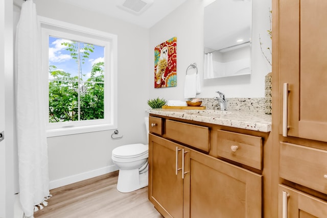 729 Burr St N, Saint Paul, MN 55130 - bathroom with vanity, wood finished floors, toilet, baseboards, and curtained shower