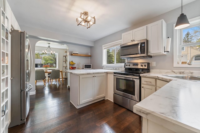331 Locust St, Duluth, MN 55811 - kitchen featuring stainless steel appliances, a chandelier, a sink, a peninsula, and light stone countertops