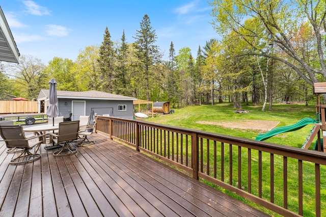331 Locust St, Duluth, MN 55811 - wooden deck featuring a playground, a lawn, outdoor dining space, and an outbuilding