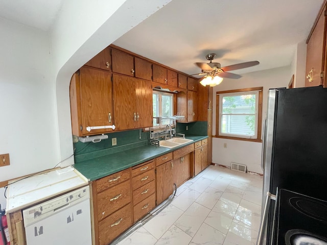 111 Park Ave, Springfield, MN 56087 - kitchen with freestanding refrigerator, white dishwasher, a sink, and brown cabinetry
