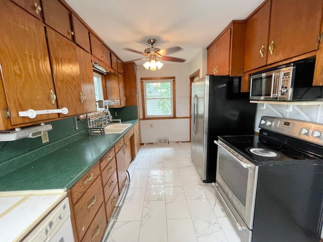 111 Park Ave, Springfield, MN 56087 - kitchen featuring stainless steel appliances, a sink, brown cabinets, and light marble finish floors