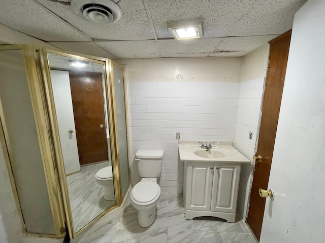 111 Park Ave, Springfield, MN 56087 - bathroom featuring toilet, a drop ceiling, marble look tiles, a shower stall, and vanity