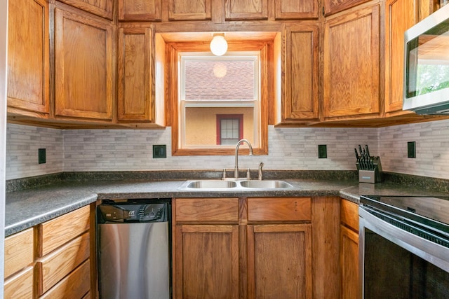 842 2nd St NW, Rochester, MN 55901 - kitchen featuring stainless steel appliances, a sink, dark countertops, and backsplash
