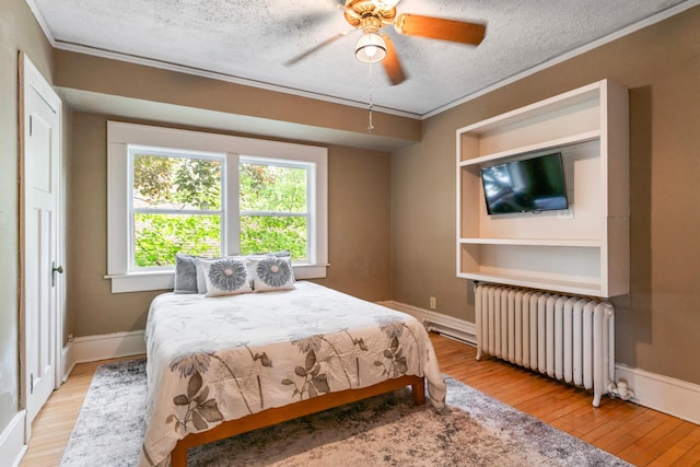842 2nd St NW, Rochester, MN 55901 - bedroom with radiator, light wood-style floors, a textured ceiling, crown molding, and baseboards