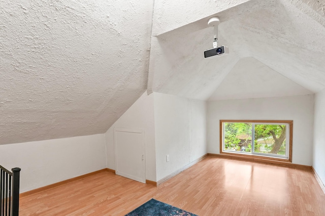 842 2nd St NW, Rochester, MN 55901 - bonus room featuring wood finished floors, lofted ceiling, a textured ceiling, and baseboards