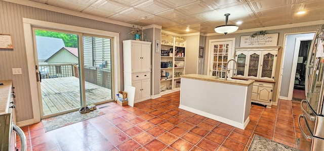 2753 Maple Ave, Slayton, MN 56172 - kitchen with a sink, light countertops, tile patterned floors, ornamental molding, and a kitchen island with sink