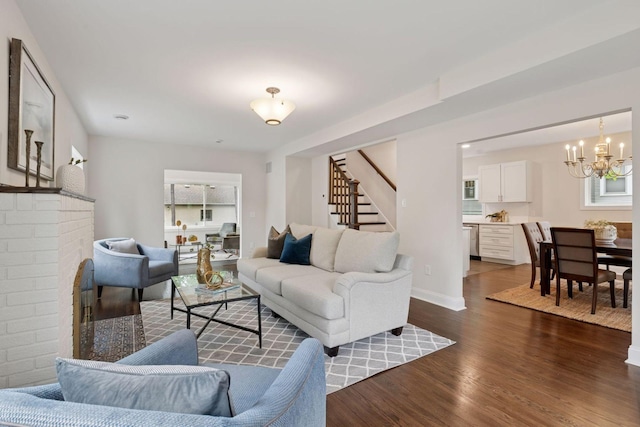 4816 3rd Ave S, Minneapolis, MN 55419 - living area with stairs, a chandelier, dark wood-style flooring, a brick fireplace, and baseboards
