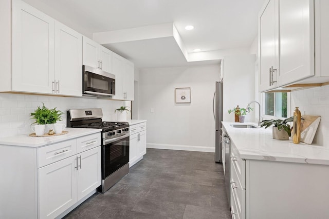 4816 3rd Ave S, Minneapolis, MN 55419 - kitchen featuring appliances with stainless steel finishes, a sink, baseboards, decorative backsplash, and white cabinetry