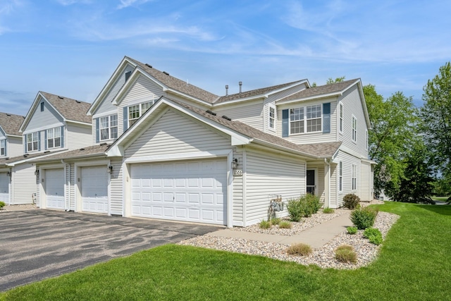 1005 Providence Dr, Shakopee, MN 55379 - view of front of home with asphalt driveway, a front yard, and roof with shingles