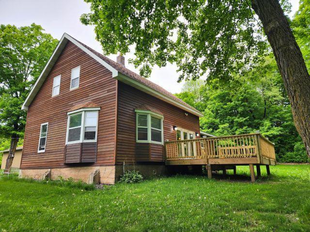 1561 240th Ave, Luck Twp, WI 54853 - back of property featuring a wooden deck, a chimney, and a lawn