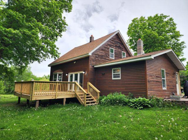 1561 240th Ave, Luck Twp, WI 54853 - rear view of property with a chimney, a deck, and a lawn