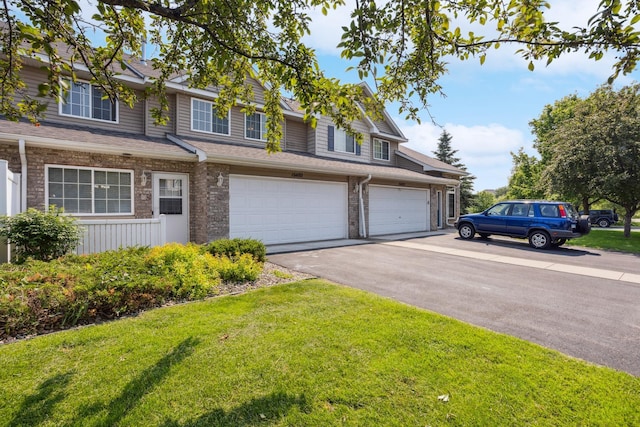 16480 Elm Creek Ln, Lakeville, MN 55044 - townhome / multi-family property featuring a front yard, driveway, an attached garage, and a shingled roof