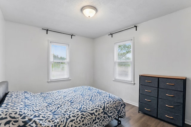 1915 Hazelwood St, Maplewood, MN 55109 - bedroom with dark wood-style flooring, a textured ceiling, and baseboards