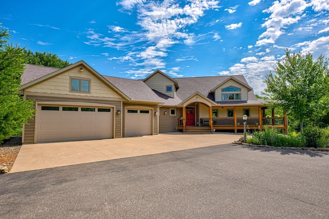 1167 56th St, Hudson, WI 54016 - view of front of home featuring an attached garage, a porch, driveway, and roof with shingles