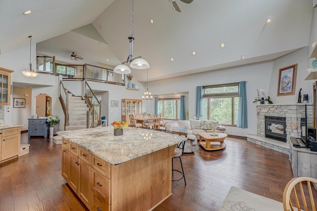 1167 56th St, Hudson, WI 54016 - kitchen with a ceiling fan, high vaulted ceiling, a fireplace, open floor plan, and a breakfast bar area