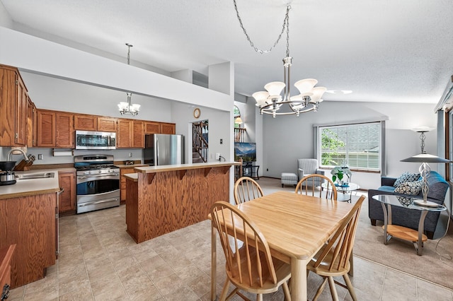 5711 Donegal Dr, Shoreview, MN 55126 - kitchen with stainless steel appliances, a chandelier, lofted ceiling, brown cabinets, and a breakfast bar